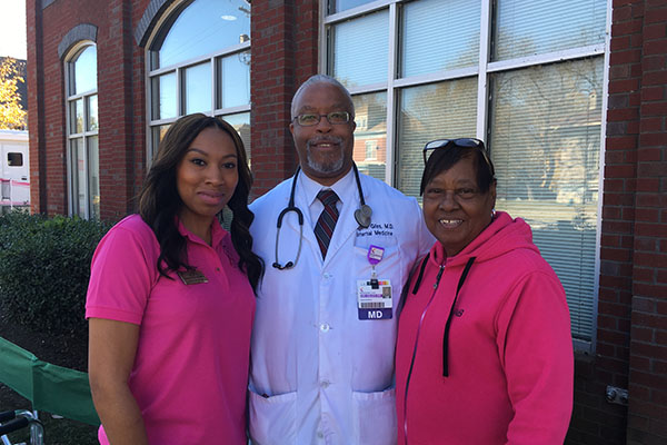 KAAAC staff standing with doctor at community mammogram screening.